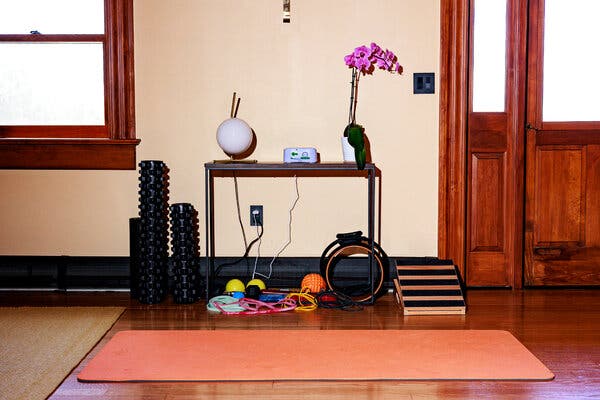 A potted orchid sits atop a table in a workout room.